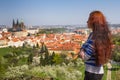 Beautiful young woman with long hair is looking on city panorama from observation desk. Prague. Czech Republic. Royalty Free Stock Photo