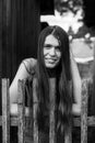 Beautiful young woman with long hair near a rustic wooden fence. Royalty Free Stock Photo