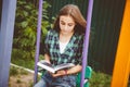 Beautiful young woman with long hair reading book outdoors in summer Royalty Free Stock Photo