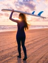 Beautiful young woman with long hair. Surf girl with surfboard on a beach at sunset or sunrise. Surfer and ocean Royalty Free Stock Photo