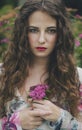 beautiful young woman in a long white dress with long wavy hair, lying on the large roots of a tree with eyes closed. Fairy tale. Royalty Free Stock Photo