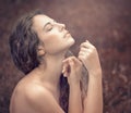 beautiful young woman in a long white dress with long wavy hair, lying on the large roots of a tree with eyes closed. Fairy tale. Royalty Free Stock Photo