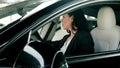 Beautiful young woman looking back through the rear view and side view mirror of a car while reversing. Safety driving Royalty Free Stock Photo