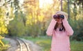 Beautiful young woman looking through binoculars in the nature Royalty Free Stock Photo