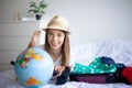 Beautiful young woman looking carefree and positive while packing her suitcase Royalty Free Stock Photo