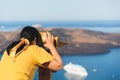 Beautiful woman looking at cruise ships with binoculars in Thira, Santorini, Greece Royalty Free Stock Photo