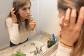 Beautiful Young Woman Looking and Examining Her Face and Makeup in Her Home Bathroom Mirror in the Morning Getting Ready for a Goo Royalty Free Stock Photo