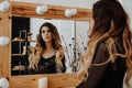 Beautiful young woman looking at her reflection in a dressing room mirror Royalty Free Stock Photo