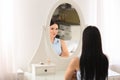 Beautiful young woman looking at herself in mirror Royalty Free Stock Photo