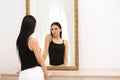 Beautiful young woman looking at herself in mirror Royalty Free Stock Photo