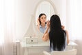 Beautiful young woman looking at herself in mirror Royalty Free Stock Photo