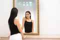 Beautiful woman looking at herself in smart mirror indoors Royalty Free Stock Photo