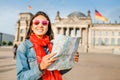 Young woman looking at map guide while standing in front of Bundestag building at sunset in Berlin. Travel in Germany Royalty Free Stock Photo