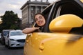 Beautiful young woman looking out of taxi window outdoors