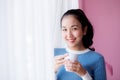 Beautiful young woman is looking out the window and holding a cup Royalty Free Stock Photo