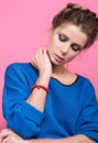 Beautiful young woman looking at a red bracelet made of beads on her wrist Royalty Free Stock Photo