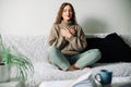 Beautiful young woman in lotus pose on bed practicing pranayama breathing techniques, finding inner balance after a