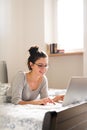 Beautiful young woman lying on bed, working. Home office. Royalty Free Stock Photo