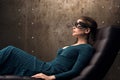 Beautiful young woman lying in a chair with his eyes closed. Black lace mask