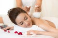 Beautiful young woman lying down on the bed relax in spa salon with massage Royalty Free Stock Photo