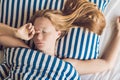 Beautiful young woman lying down in bed and sleeping. Do not get enough sleep concept