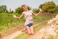 Beautiful Young Woman lying on the field in green grass and blowing dandelion. Outdoors. Enjoy Nature. Healthy Smiling Girl on spr Royalty Free Stock Photo