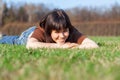 Beautiful Young Woman lying on a field, green grass. Outdoors Enjoy Nature. Royalty Free Stock Photo