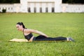 Beautiful young woman lying on a yellow mattress doing pilates or yoga, double leg kick exercises