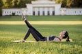 Beautiful young woman lying on a yellow mattress doing pilates or yoga, the hundred intermediate exercises Royalty Free Stock Photo