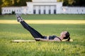 Beautiful young woman lying on a yellow mattress doing pilates or yoga, the hundred intermediate exercises Royalty Free Stock Photo