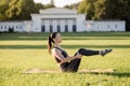 Beautiful young woman lying on a yellow mattress doing pilates or yoga, rolling back beginner exercises