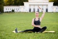 Beautiful young woman lying on a yellow mattress doing pilates or yoga, the saw exercises Royalty Free Stock Photo