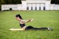 Beautiful young woman lying on a yellow mattress doing pilates or yoga, swan dive expert exercises