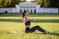 Beautiful young woman lying on a yellow mattress doing pilates or yoga, spine twist beginner exercises