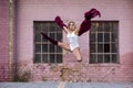 Ballet dancer girl jump on street in front of pink wall Royalty Free Stock Photo