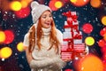 Christmas and New Year holidays. Happy woman holding gift boxes on winter background with snow and lights in black Royalty Free Stock Photo