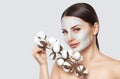 A beautiful young woman makes a moisturizing mask on her face, she is holding a cotton flower in her hands Royalty Free Stock Photo