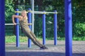 Beautiful young woman makes sport exercises on the sport ground
