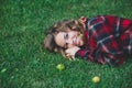 Beautiful young woman in a male flannel shirt lying on green grass Royalty Free Stock Photo