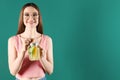 Beautiful young woman with Mason jar of detox lemonade on green background. Space for text