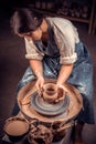 Beautiful young woman master demonstrates the process of making ceramic dishes using the old technology. Handwork.