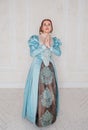 Beautiful young woman in medieval style blue dress praying Royalty Free Stock Photo