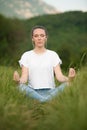 Beautiful young woman meditate on meadou na early summer evening Royalty Free Stock Photo