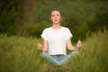 Beautiful young woman meditate on meadou na early summer evening Royalty Free Stock Photo