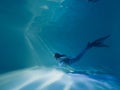 Woman with mermaid tail swims and dives underwater