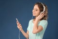 Beautiful young woman with mobile phone listening to music on color background Royalty Free Stock Photo