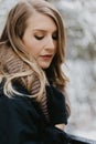 Beautiful Young Woman Modeling Bundled in Trendy Gloves, Coat, and Scarf Smiling and Having Fun With Snow Outside in Nature Around Royalty Free Stock Photo