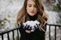 Beautiful Young Woman Modeling Bundled in Trendy Gloves, Coat, and Scarf Smiling and Having Fun With Snow Outside in Nature Around Royalty Free Stock Photo