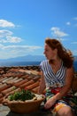 Beautiful young woman in Monemvasia town sitting on a roof. Greece