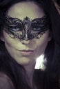 Beautiful young woman in mysterious black Venetian mask Royalty Free Stock Photo